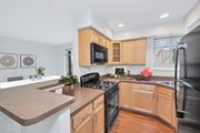 Arlington apartment for rent - a kitchen with maple cabinets and black appliances