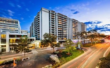 Arlington apartment for rent - A modern building with a parking lot in front of it.