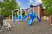 Woodbridge apartment for rent - A playground with a blue slide and a grey bench.