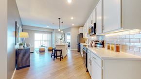 Lakeville apartment for rent - A modern kitchen with white cabinets and a wooden floor.