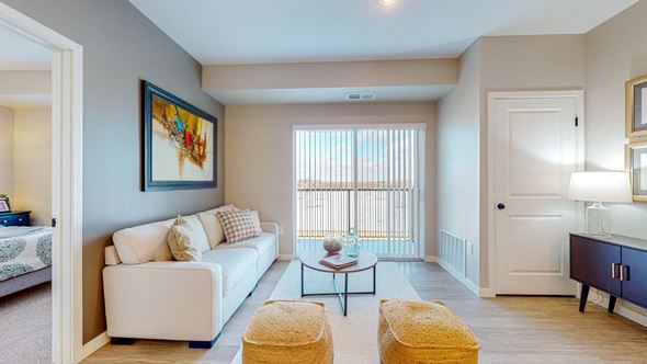 Lakeville apartment for rent - A living room with a white couch, a yellow ottoman, and a painting on the wall.