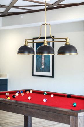 Duluth apartment for rent - a row of pendants hanging over a pool table with a red and white blanket