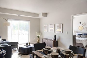 Shakopee apartment for rent - A modern living room with a dining table set for four.