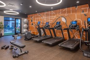 Richfield apartment for rent - a gym with cardio equipment and a wall with a graphic of exercise balls