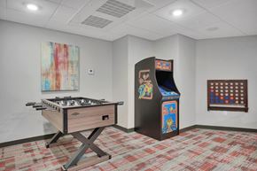 Shakopee apartment for rent - A room with a pool table, a pinball machine, and a painting on the wall.