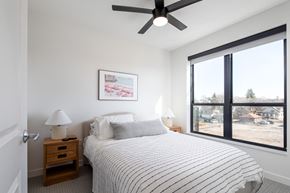 Minneapolis apartment for rent - a bedroom with a bed and a ceiling fan and a large window