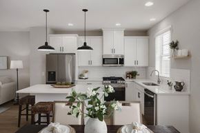 Mound townhouse for rent - A modern kitchen with a dining table set for two.