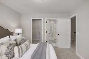 Mound townhouse for rent - A bedroom with a bed, couch, and mirror.