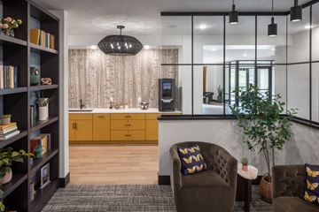 Minnetonka apartment for rent - A modern living room with a brown sofa and a bookshelf filled with books.