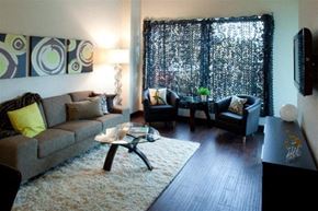 Grand Rapids apartment for rent - A living room with a grey couch, a coffee table, and a black chair.
