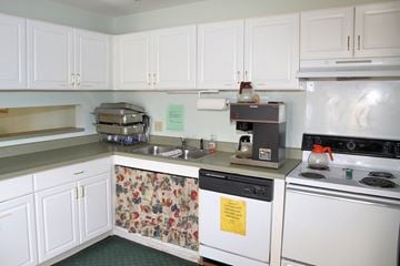Lansing apartment for rent - A kitchen with white cabinets and a floral dishwasher.