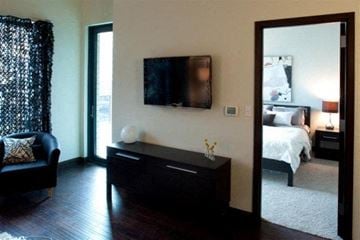 Grand Rapids apartment for rent - A black sofa sits in a living room with a television mounted on the wall.