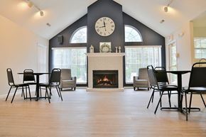 Lansing townhouse for rent - the gathering place at gardner village community room with fireplace and tables and chairs