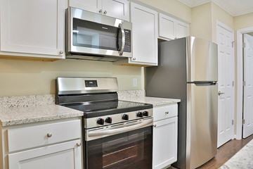 East Lansing townhouse for rent - A kitchen with white cabinets and stainless steel appliances.