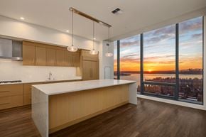 Bellevue apartment for rent - A modern kitchen with wooden cabinets and a large island at Two Lincoln Tower, Bellevue, WA.