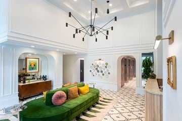 Victoria apartment for rent - A living room with a green couch and a chandelier.