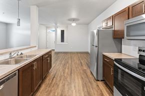 Spokane Valley townhouse for rent - A kitchen with wooden cabinets and stainless steel appliances.at The Brix Apartments, Spokane Valley, Washington