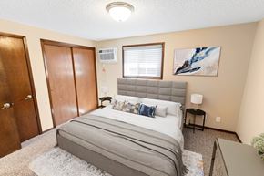 Spokane apartment for rent - A bedroom with a bed, nightstand, and a painting on the wall.