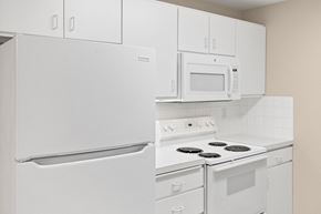 Spokane apartment for rent - A white kitchen with a refrigerator, microwave, oven, and stove.