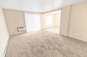 Spokane apartment for rent - A spacious room with beige walls and carpeted floor.