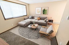 Spokane apartment for rent - A living room with a grey couch, a coffee table, and a rug.