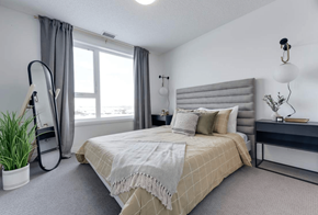Edmonton apartment for rent - A bedroom with a large bed and a window with curtains.