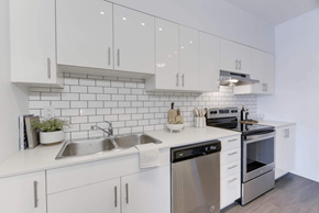 Edmonton apartment for rent - A modern kitchen with white cabinets and stainless steel appliances.