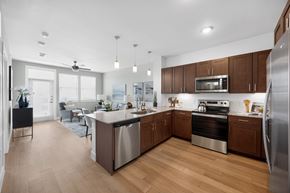 Lewisville apartment for rent - A modern kitchen with wooden cabinets and stainless steel appliances.