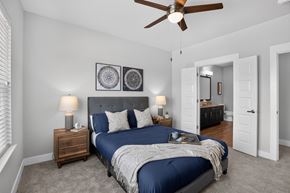 Fort Worth apartment for rent - A bedroom with a bed, nightstands, and a ceiling fan.