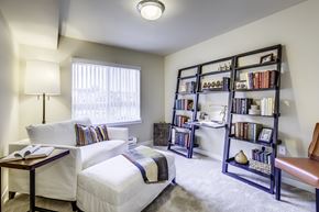 Olympia apartment for rent - A cozy bedroom with a bed, a table, and a bookshelf.