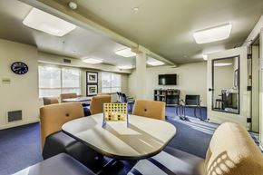 Olympia apartment for rent - A conference room with a table, chairs, and a television.