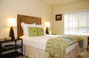 Coeur D Alene apartment for rent - A bedroom with a large bed and a window with blinds.
