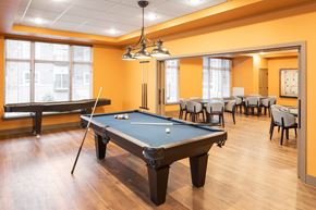 Ramsey apartment for rent - A pool table is in the middle of a room with chairs and a bench.
