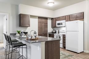 Ramsey apartment for rent - A kitchen with white appliances and brown cabinets.