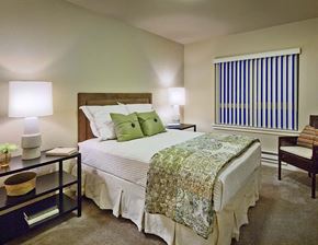 Spokane apartment for rent - A bedroom with a bed, nightstand, and window.