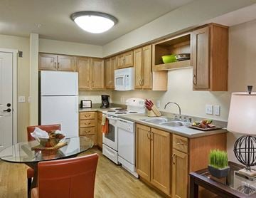 Spokane apartment for rent - A kitchen with wooden cabinets and white appliances.
