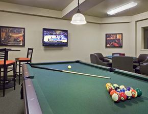 Spokane apartment for rent - A pool table with a sports game on television in the background.