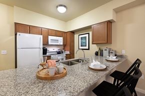 Round Rock apartment for rent - A kitchen with granite countertops and a white refrigerator.