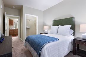 Austin apartment for rent - A bedroom with a bed, nightstand, and a mirror.