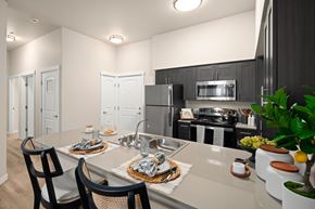 Bend apartment for rent - A modern kitchen with a dining table set for two.