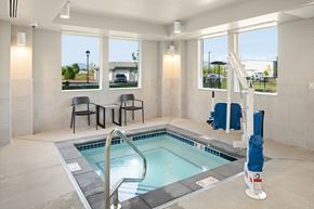 Burlington apartment for rent - A small indoor pool with a ladder and a few chairs.