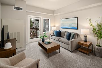 Burlington apartment for rent - A living room with a grey couch, a coffee table, a chair, and a painting on the wall.