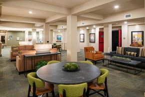 Lacey apartment for rent - A round table with a green plant on it is surrounded by chairs in a spacious room.