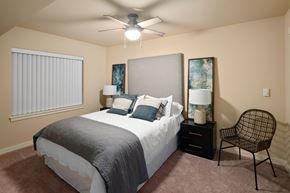 Lacey apartment for rent - A bedroom with a bed, chair, and ceiling fan.