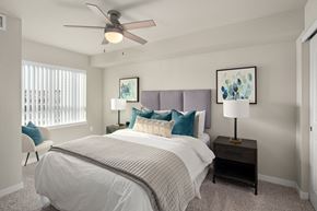 Spokane Valley apartment for rent - A bedroom with a bed, nightstand, and a ceiling fan.