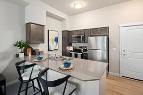 Richland apartment for rent - A kitchen with a white counter top and black chairs.