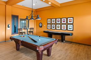 San Antonio apartment for rent - A pool table in a room with orange walls.
