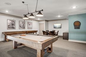 Cedar Park apartment for rent - A pool table is in the middle of a room with a light blue wall and a chair.