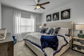 Fort Worth apartment for rent - A bedroom with a large bed and a ceiling fan.