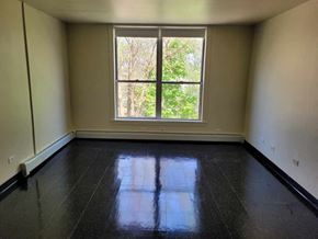 Chicago apartment for rent - A room with a large window and black floor tiles.